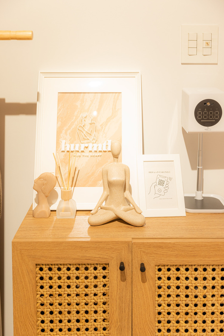 エントランスの靴箱の上には、SILENT SIRENのあいにゃんによるイラスト、ヨガの置物、アロマ、アルコール消毒マシンを設置。